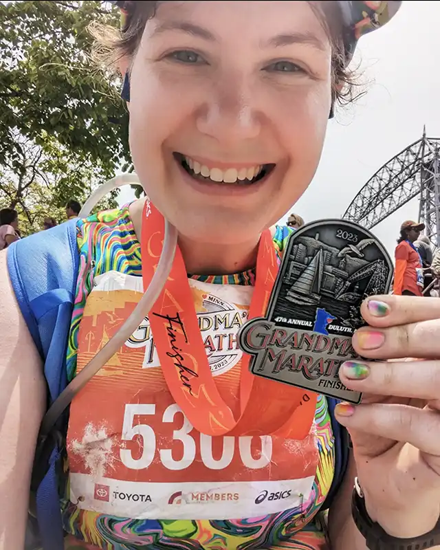 Woman holding medal from marathon